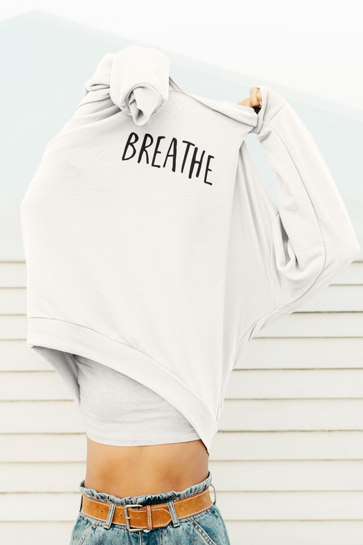 Model trägt weißes Oversized Hoodie mit Motiv BREATHE	